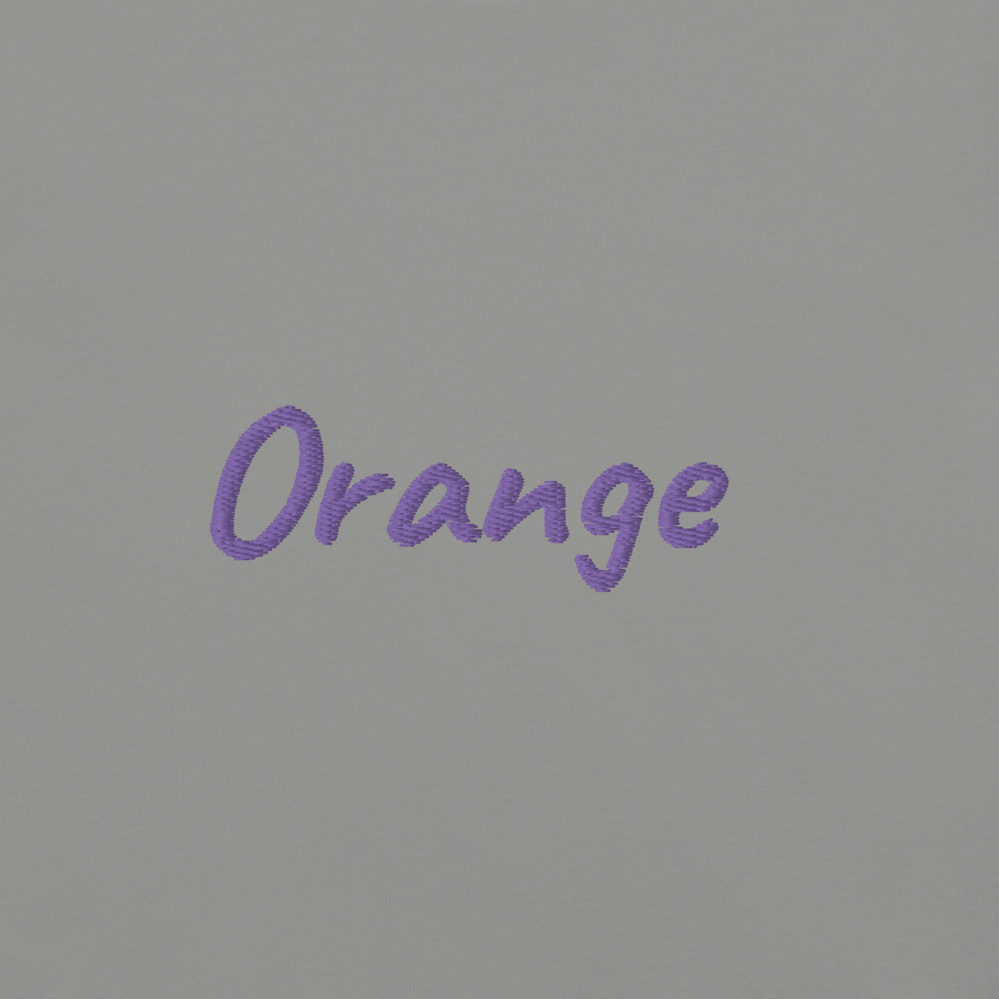 Close-up view of the word 'Orange' embroidered in Purple on a Gray T-shirt. This detailed shot highlights the quality and precision of the embroidery, showcasing the unique design element that adds a bold touch to the T-shirt.