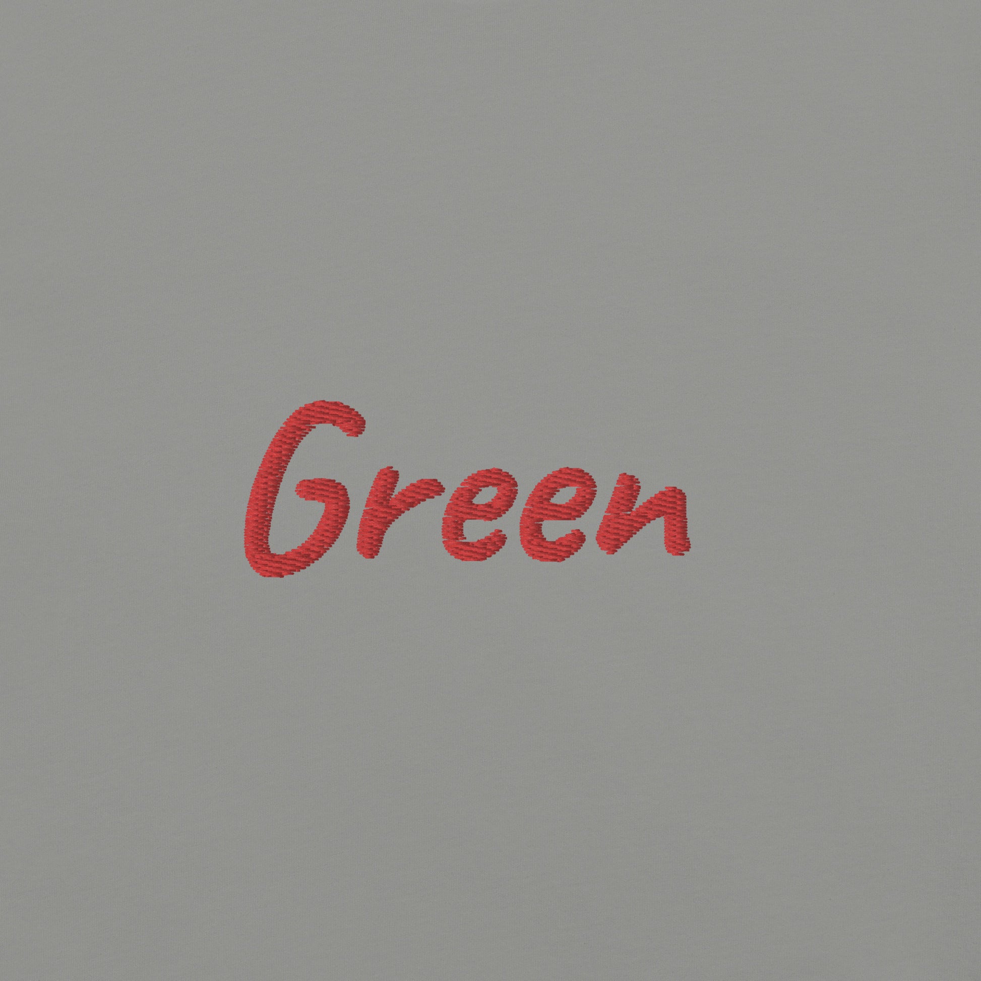 Close-up view of the word 'Green' embroidered in Red on a Gray T-shirt. This detailed shot highlights the quality and precision of the embroidery, showcasing the unique design element that adds a bold touch to the T-shirt.